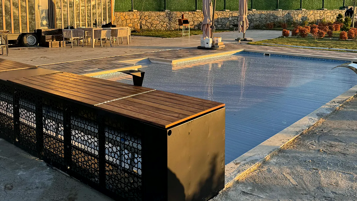 Pendik'teki kurulumda Bosphorus X otomatik havuz kapatma sistemi tam kapalı konumda; ahşap oturma yüzeyli kasa havuzun kenarında